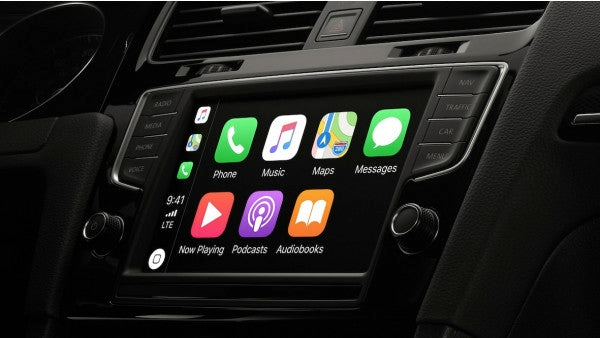 Car dashboard with a GPS device in the center, surrounded by knobs and a steering wheel on the left side